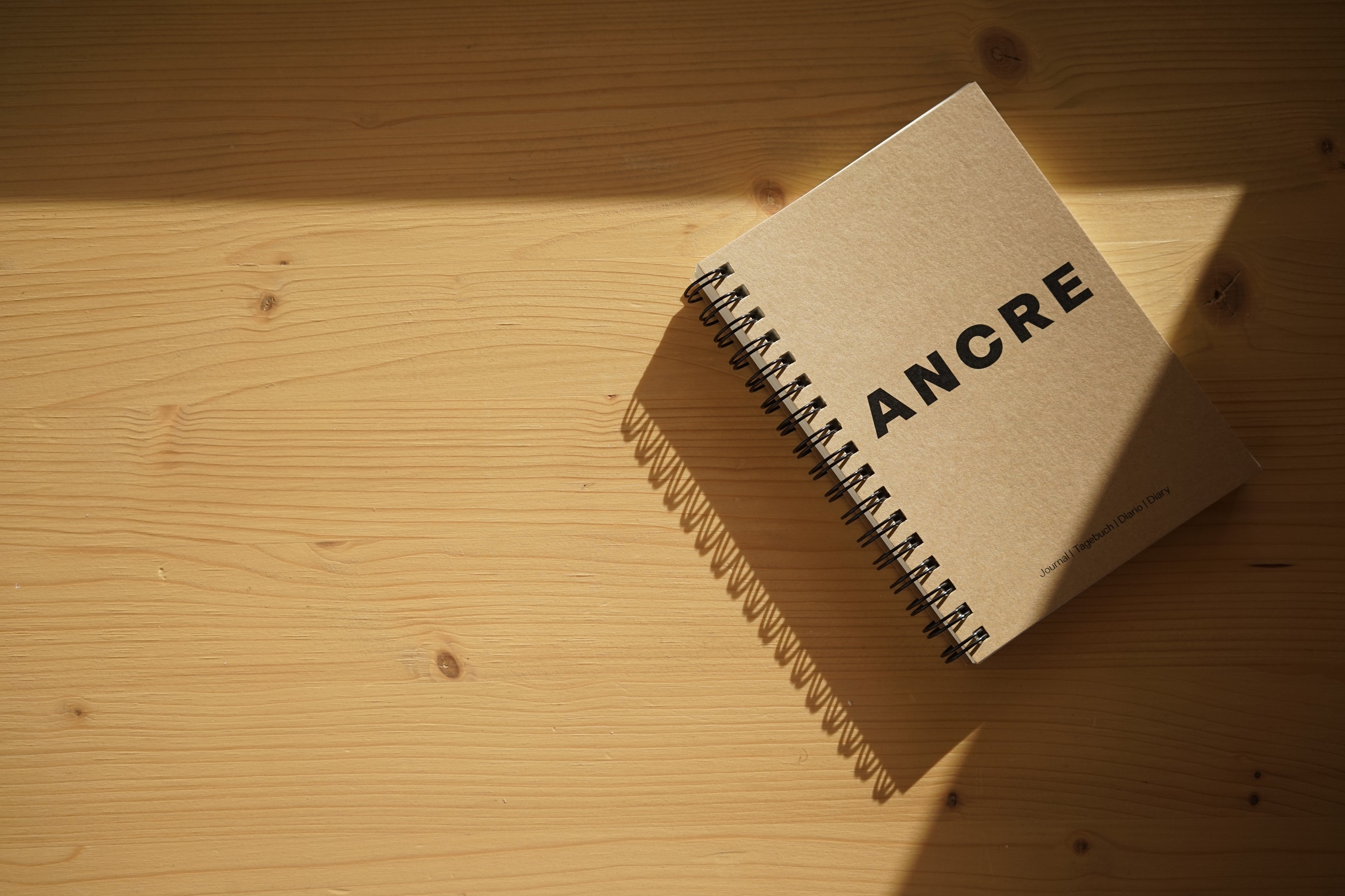 Photographie d'un carnet Ancre sur un plan de travail ensoleillé 