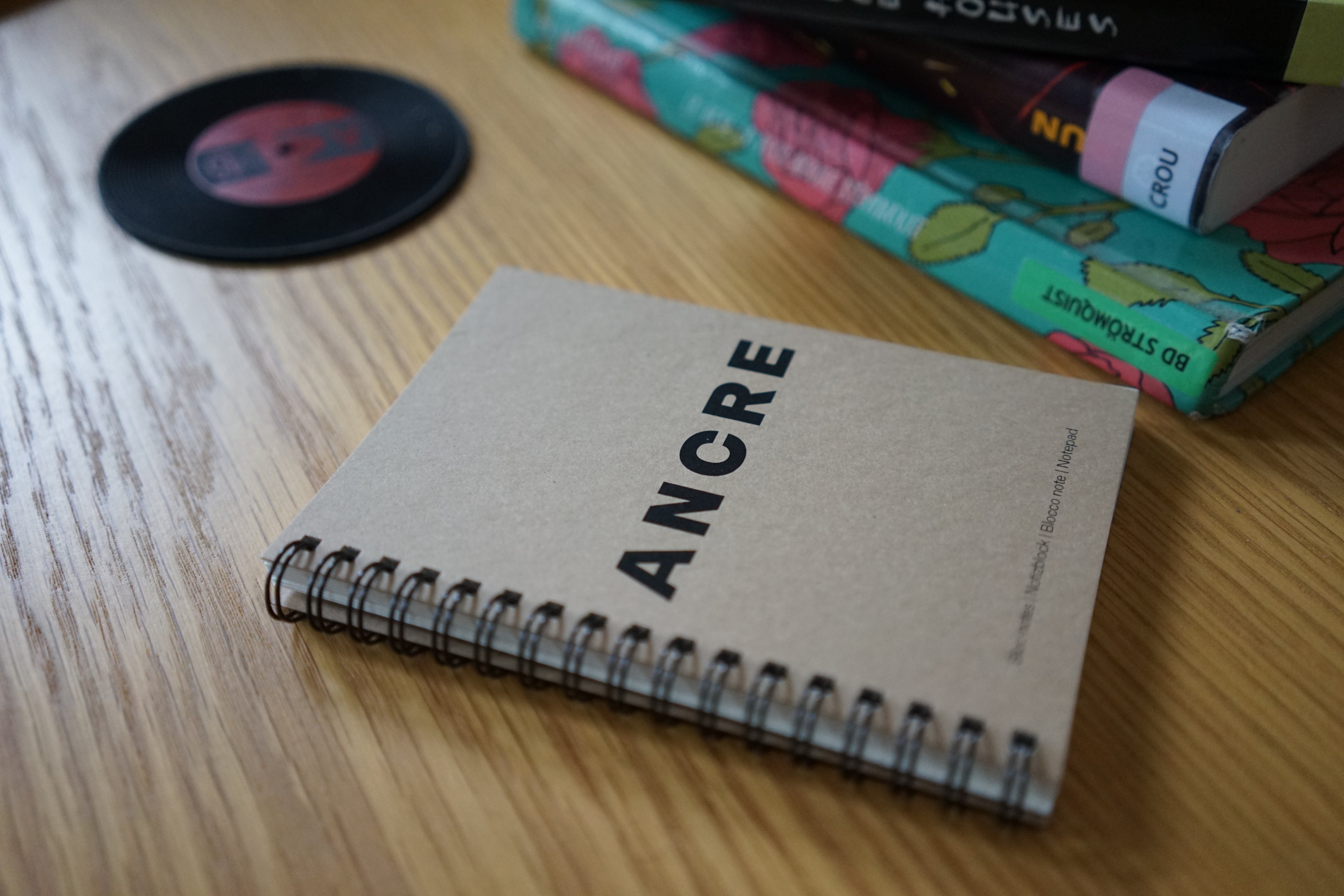 Bloc-notes Ancre posé sur une table avec des livres empruntés à la bibliothèque de Vevey